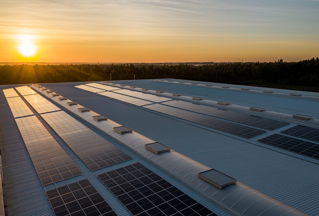 Impianto fotovoltaico sulla copertura di uno stabilimento industriale al tramonto
